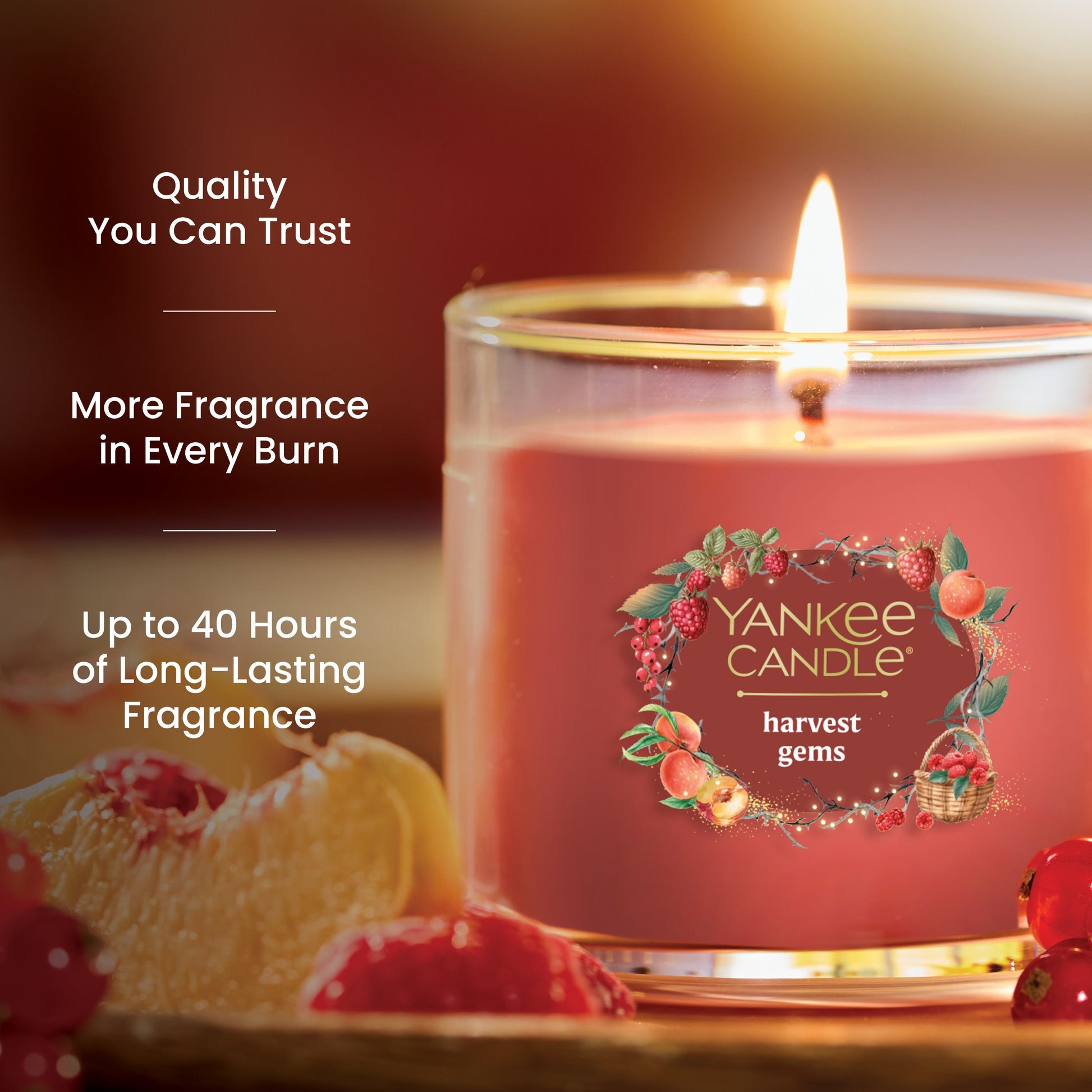 Red glass jar candle with fruit accents, promises up to 40 hours of long-lasting, quality fragrance burn time