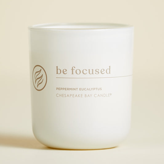 chesapeake bay candle intentions collection be focused peppermint eucalyptus medium two wick candle in a pastel yellow backdrop